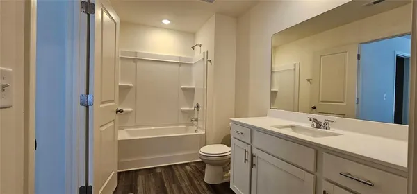 a bathroom with a granite countertop sink toilet a shower and a mirror