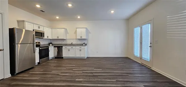 a kitchen with stainless steel appliances granite countertop a refrigerator and a stove top oven