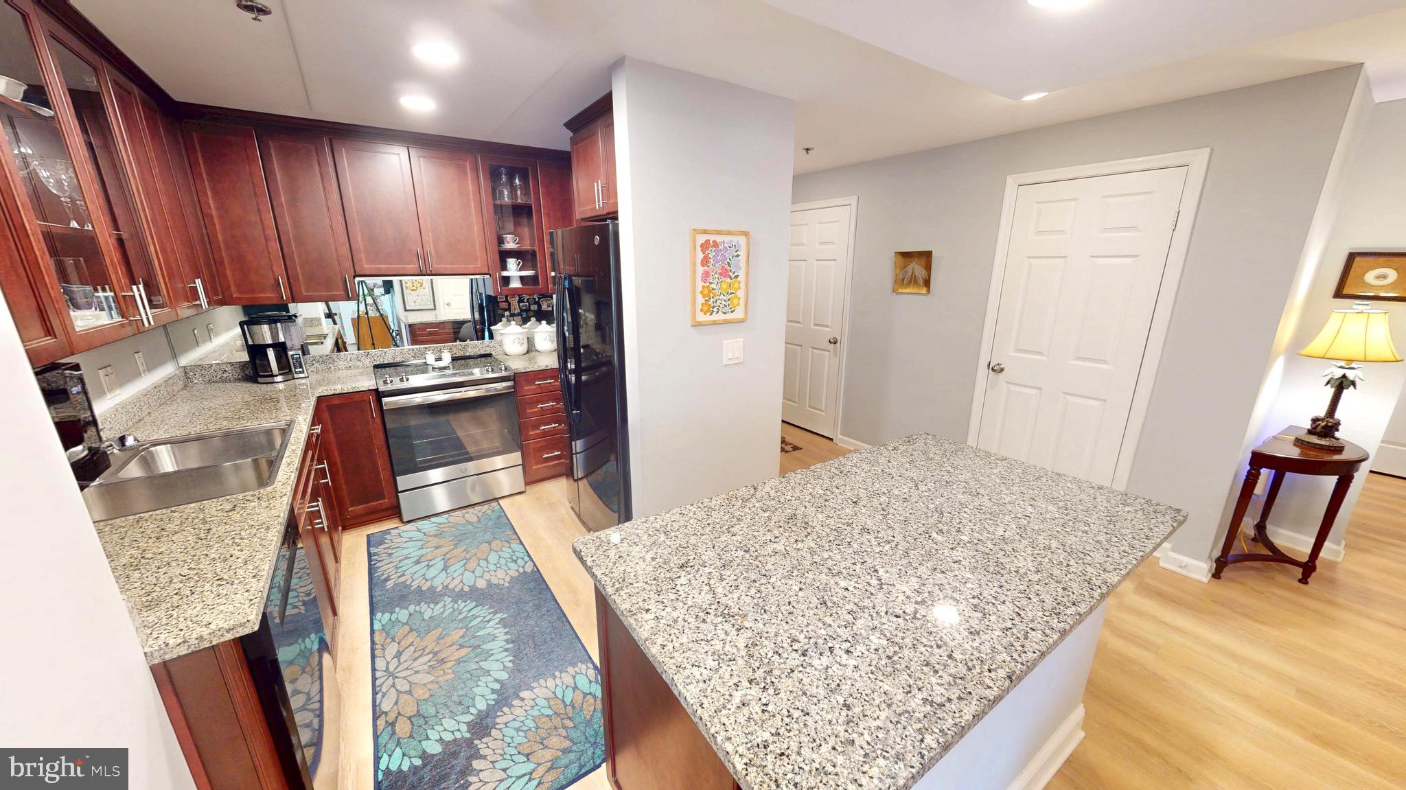 960 Fell Street, Unit 609 Baltimore, MD 21231 - Photo 2 of 45 a kitchen with stainless steel appliances granite countertop sink stove refrigerator and wooden floor