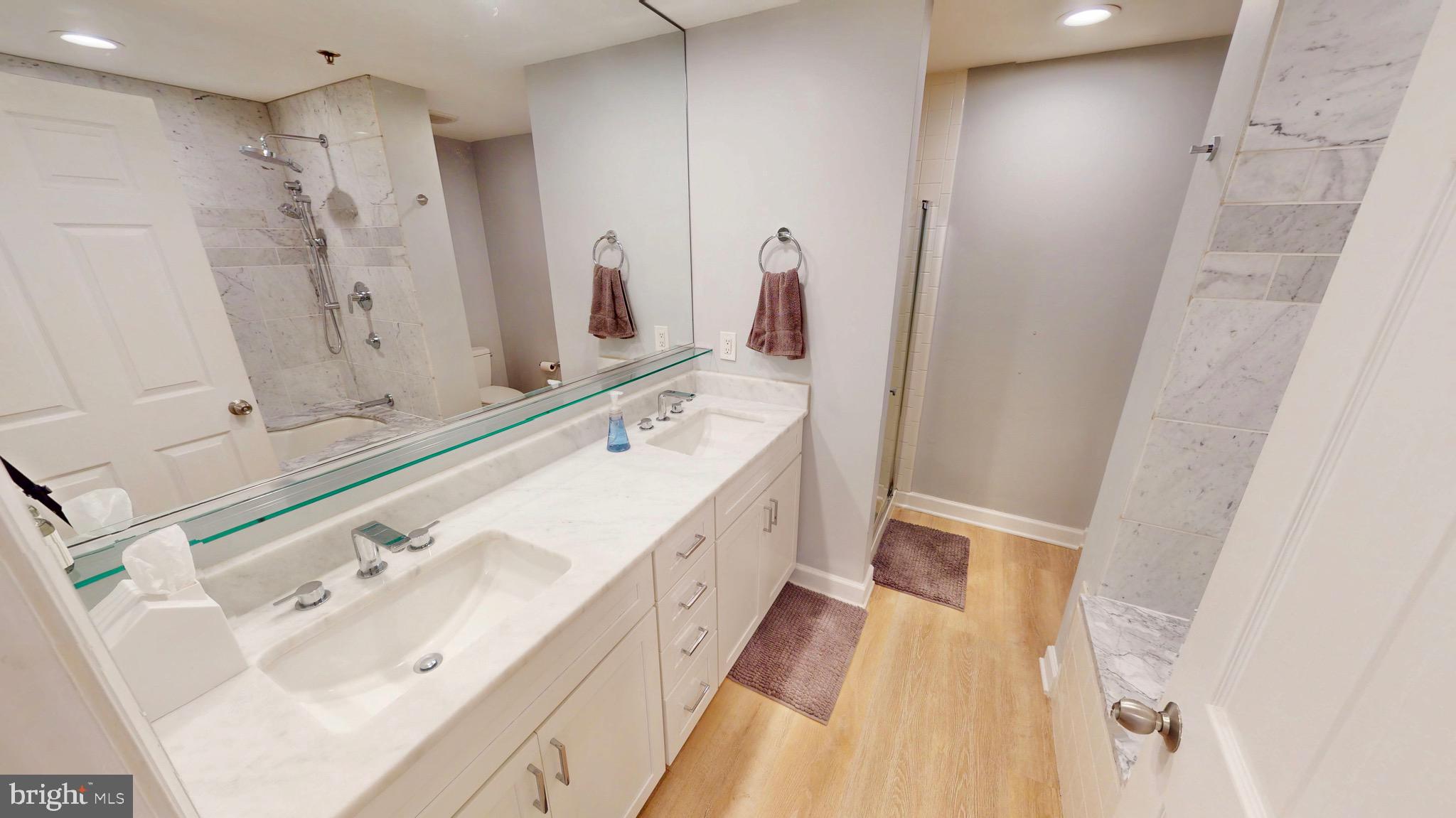 960 Fell Street, Unit 609 Baltimore, MD 21231 - Photo 27 of 45 a spacious bathroom with a double vanity sink and a mirror