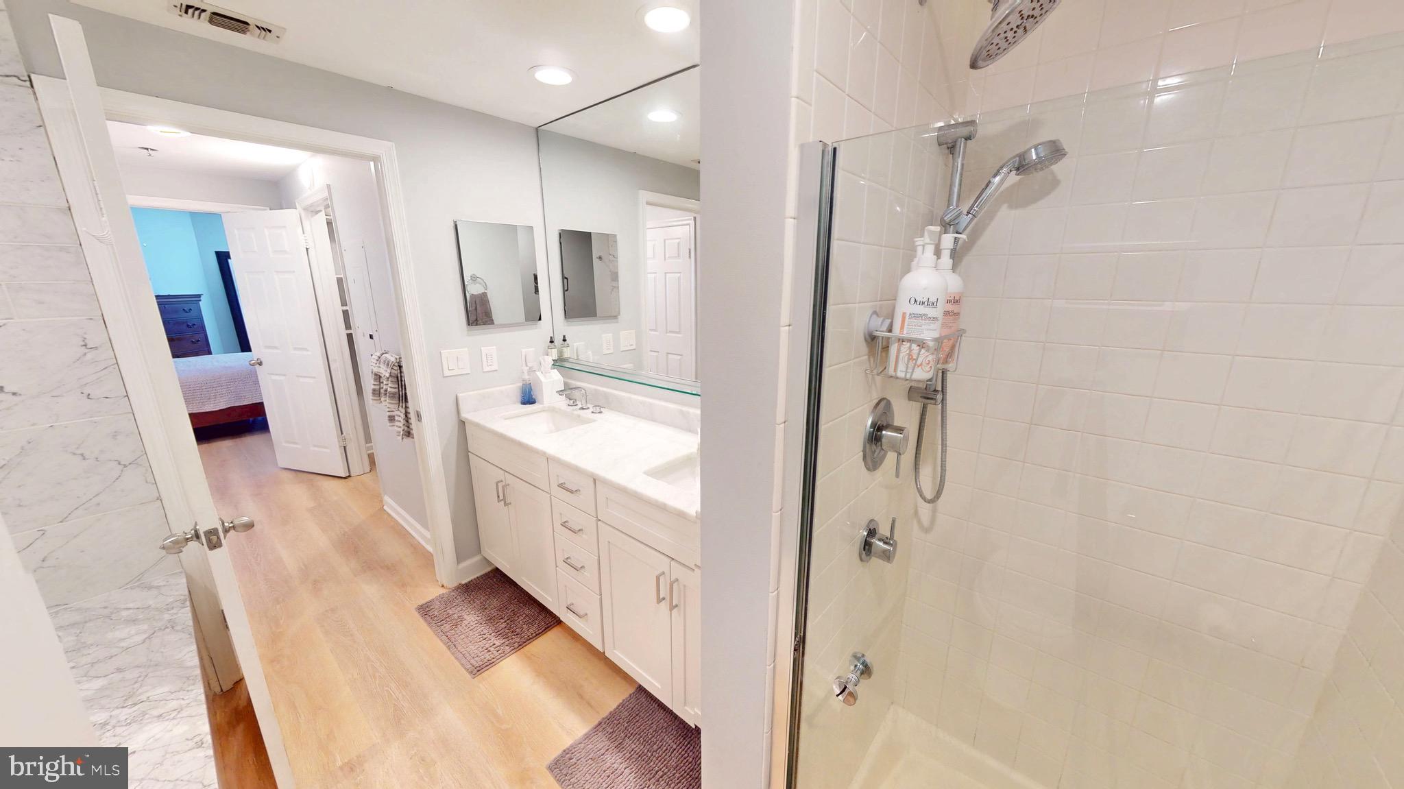 960 Fell Street, Unit 609 Baltimore, MD 21231 - Photo 28 of 45 a spacious bathroom with a double vanity sink a mirror and shower