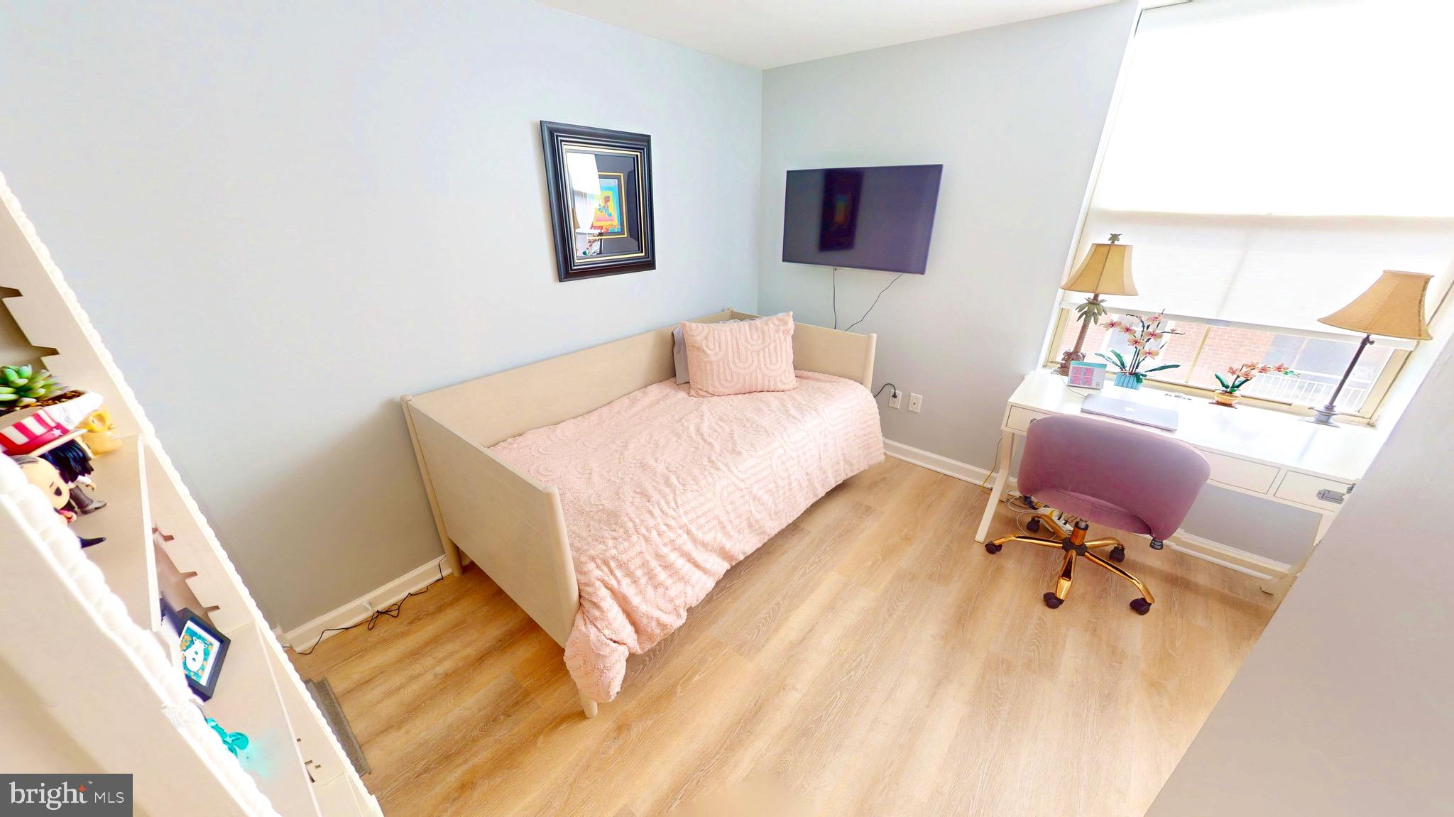 960 Fell Street, Unit 609 Baltimore, MD 21231 - Photo 32 of 45 a bedroom with a bed and wooden floor