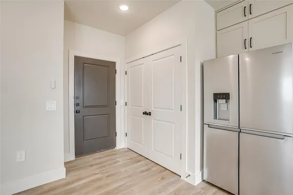 a view of a kitchen with a refrigerator and wooden floor