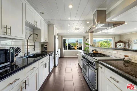 a kitchen with stainless steel appliances a stove a sink and a refrigerator