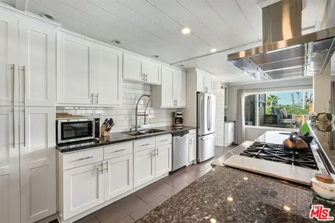 a view of a room with furniture a potted plant and wooden floor