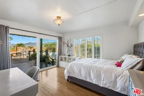 a bedroom with a bed and a wooden floor