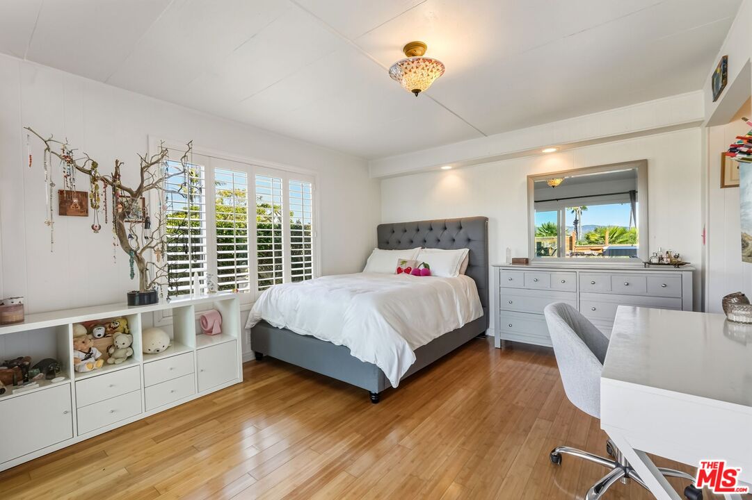 29500 Heathercliff Road, Unit 87 Malibu, CA 90265 - Photo 21 of 58 a bedroom with a bed and a wooden floor