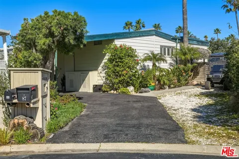 a front view of a house with a yard glass windows and refrigerator