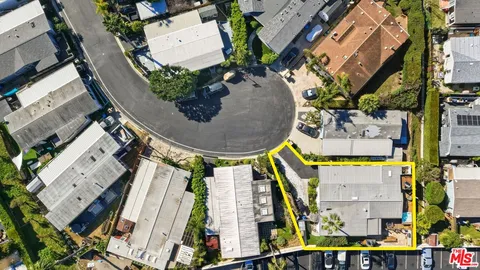 an aerial view of a house with a garden and lake view