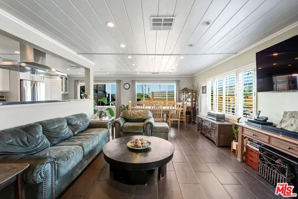 a living room with furniture and a view of kitchen
