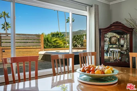 a view of a dining room with furniture a chandelier and wooden floor