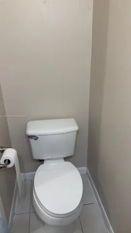 a white toilet sitting next to a white wall