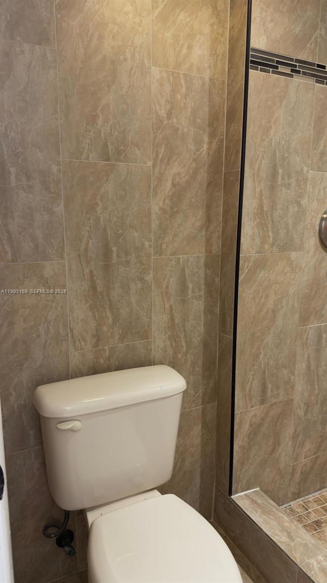 3908 Southwest 67th Terrace, Unit 112 Davie, FL 33314 - Photo 3 of 17 a white toilet sitting next to a shower