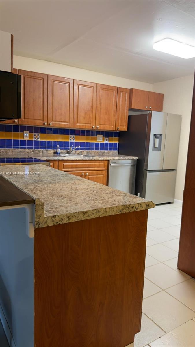 3908 Southwest 67th Terrace, Unit 112 Davie, FL 33314 - Photo 6 of 17 a living room with stainless steel appliances granite countertop a barbecue grill and a refrigerator with wooden floor