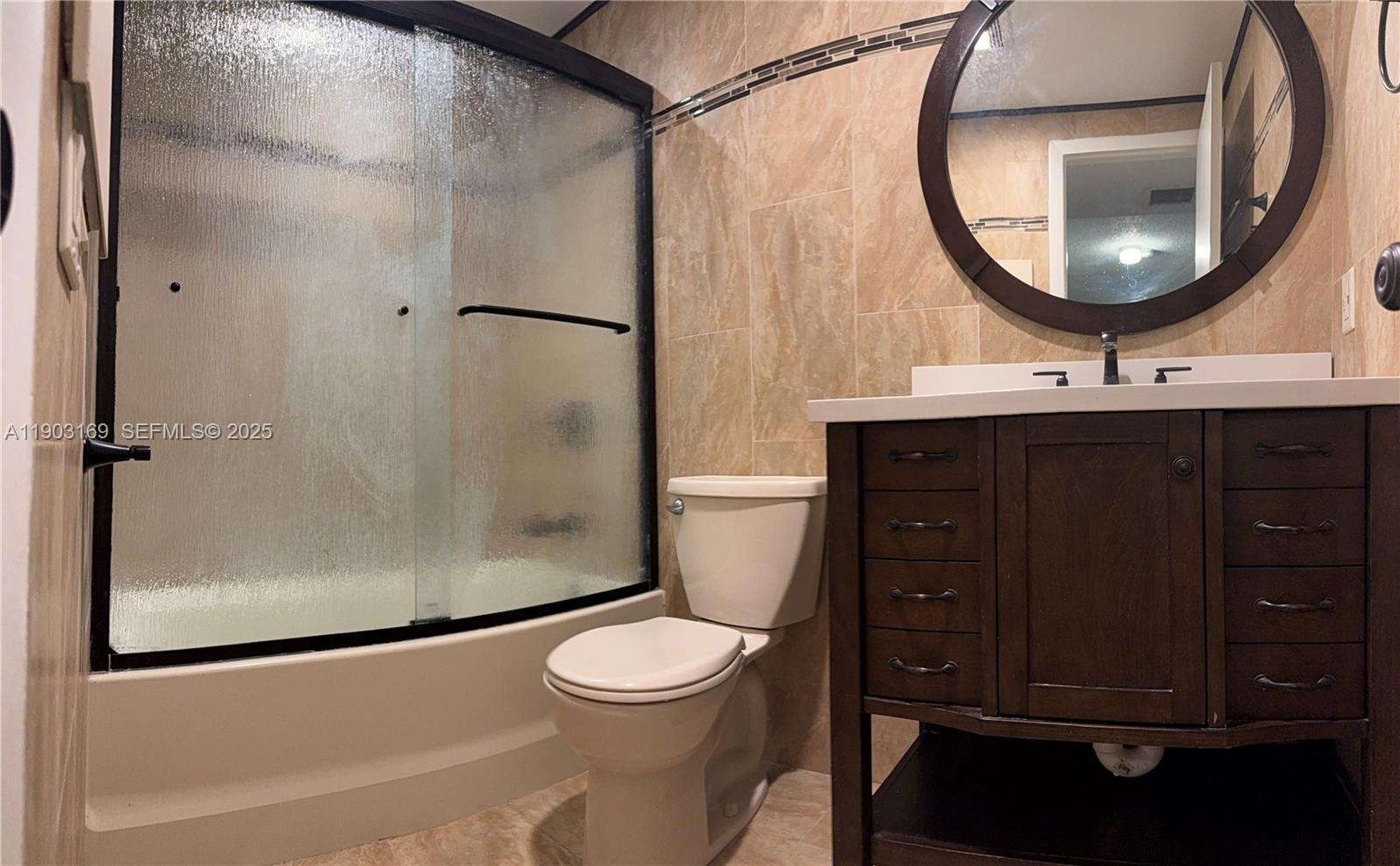 3908 Southwest 67th Terrace, Unit 112 Davie, FL 33314 - Photo 9 of 17 a bathroom with a toilet a sink and a mirror