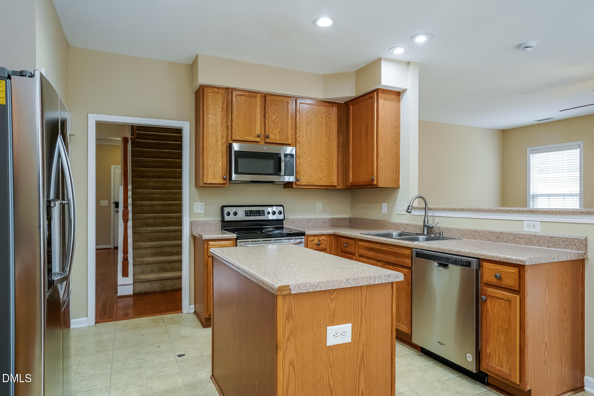 2279 Lazy River Drive Raleigh, NC 27610 - Photo 6 of 24 a kitchen with stainless steel appliances granite countertop a sink stove microwave and refrigerator