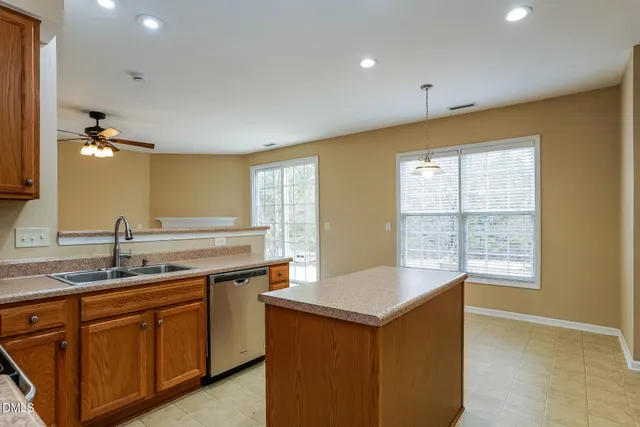 a kitchen with stainless steel appliances granite countertop a stove top oven a refrigerator a sink and dishwasher
