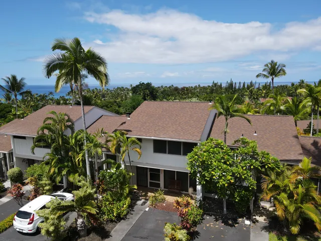 front view of house with a yard and potted plants