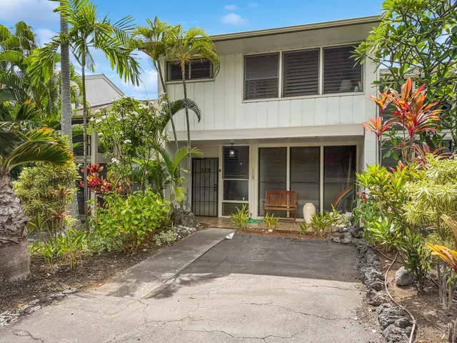 a front view of a house with garden and sitting area