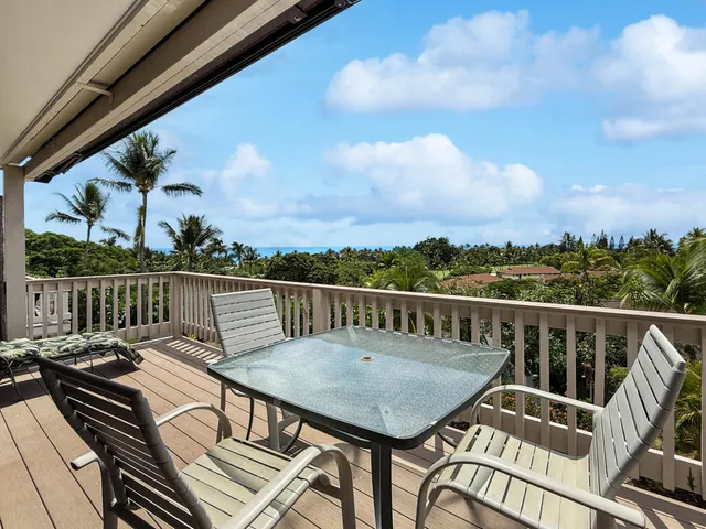 a view of a balcony with wooden floor and outdoor seating