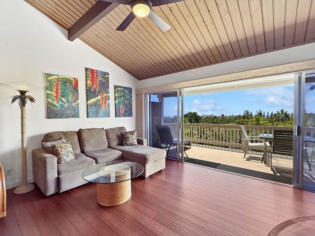 a living room with furniture a ceiling fan and wooden floor