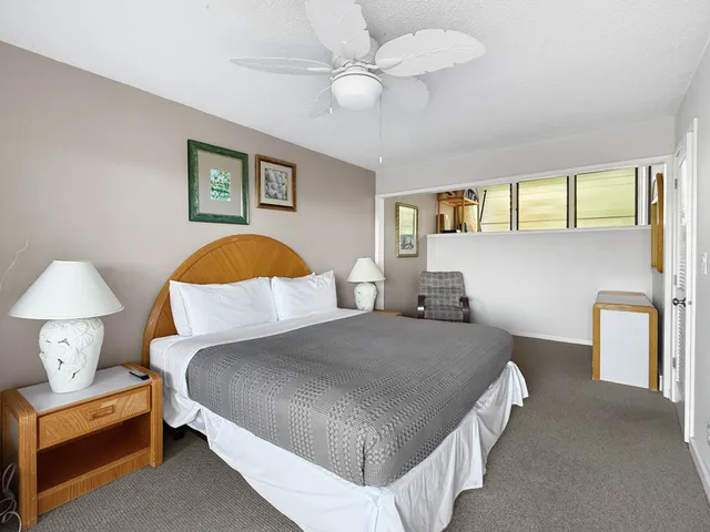 a bedroom with a bed and a lamp on dresser