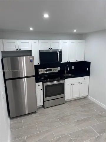 a kitchen with stainless steel appliances a refrigerator a stove a microwave and cabinets
