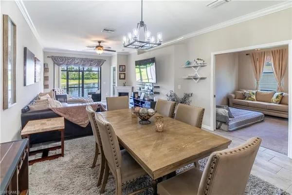 a view of a dining room with furniture a chandelier and wooden floor