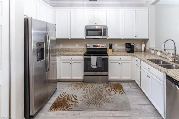 a kitchen with stainless steel appliances granite countertop a refrigerator stove and sink