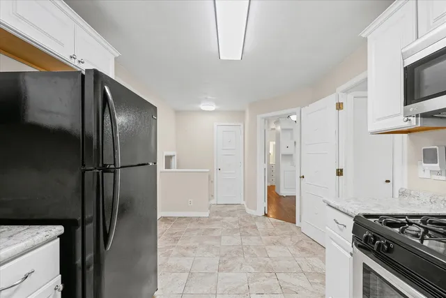 a kitchen with stainless steel appliances granite countertop a refrigerator and a stove top oven