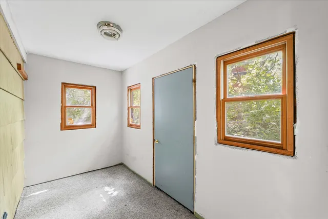 a view of an empty room with windows and closet