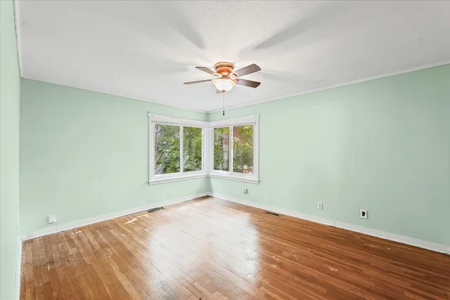 wooden floor in an empty room with a window