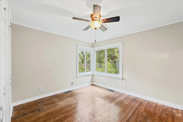 wooden floor in an empty room with a window