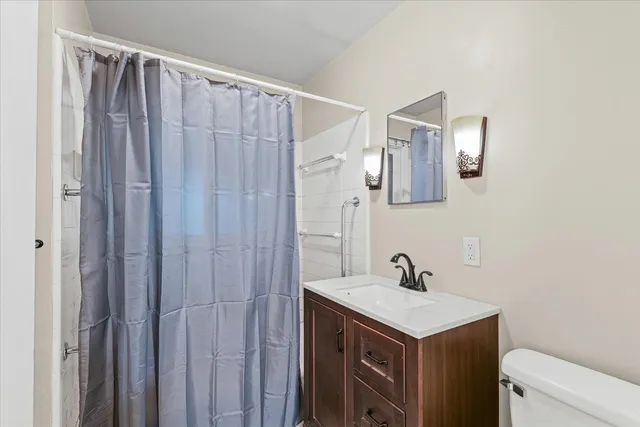 a bathroom with a sink a toilet and shower curtain