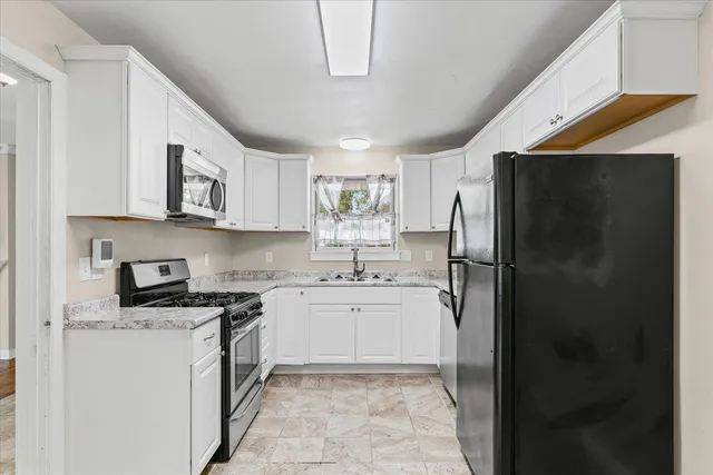 a kitchen with stainless steel appliances granite countertop a refrigerator and a stove