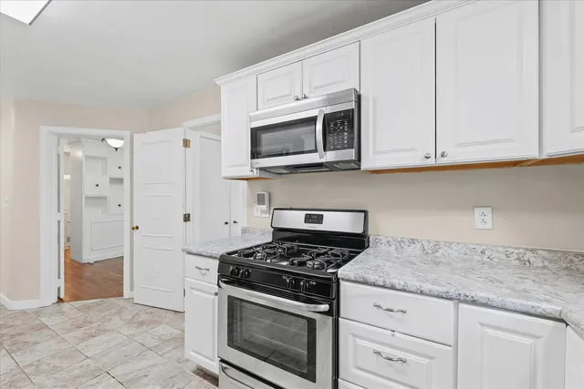 a kitchen with granite countertop cabinets stainless steel appliances and a sink