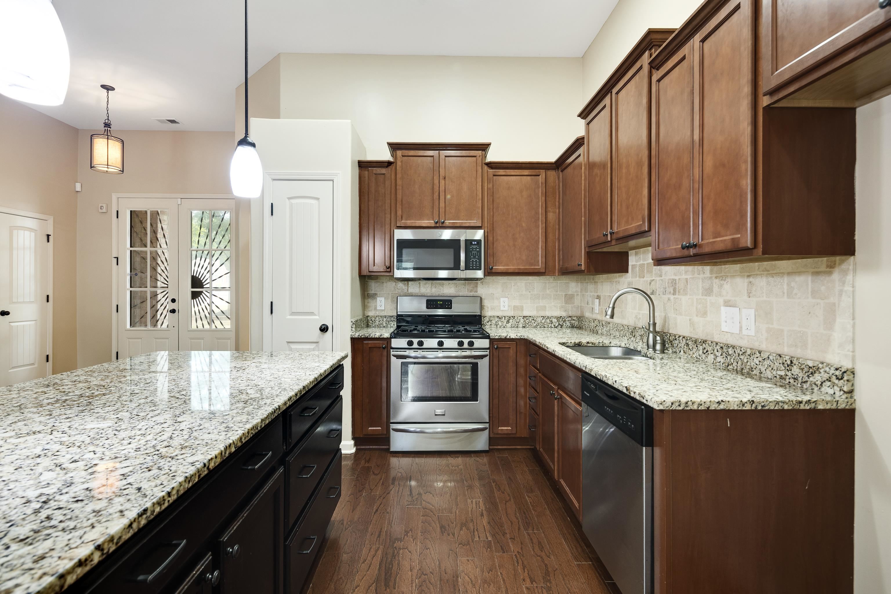 379 Shelton Road Collierville, TN 38017 - Photo 11 of 32 a kitchen with stainless steel appliances granite countertop a sink a stove and a refrigerator