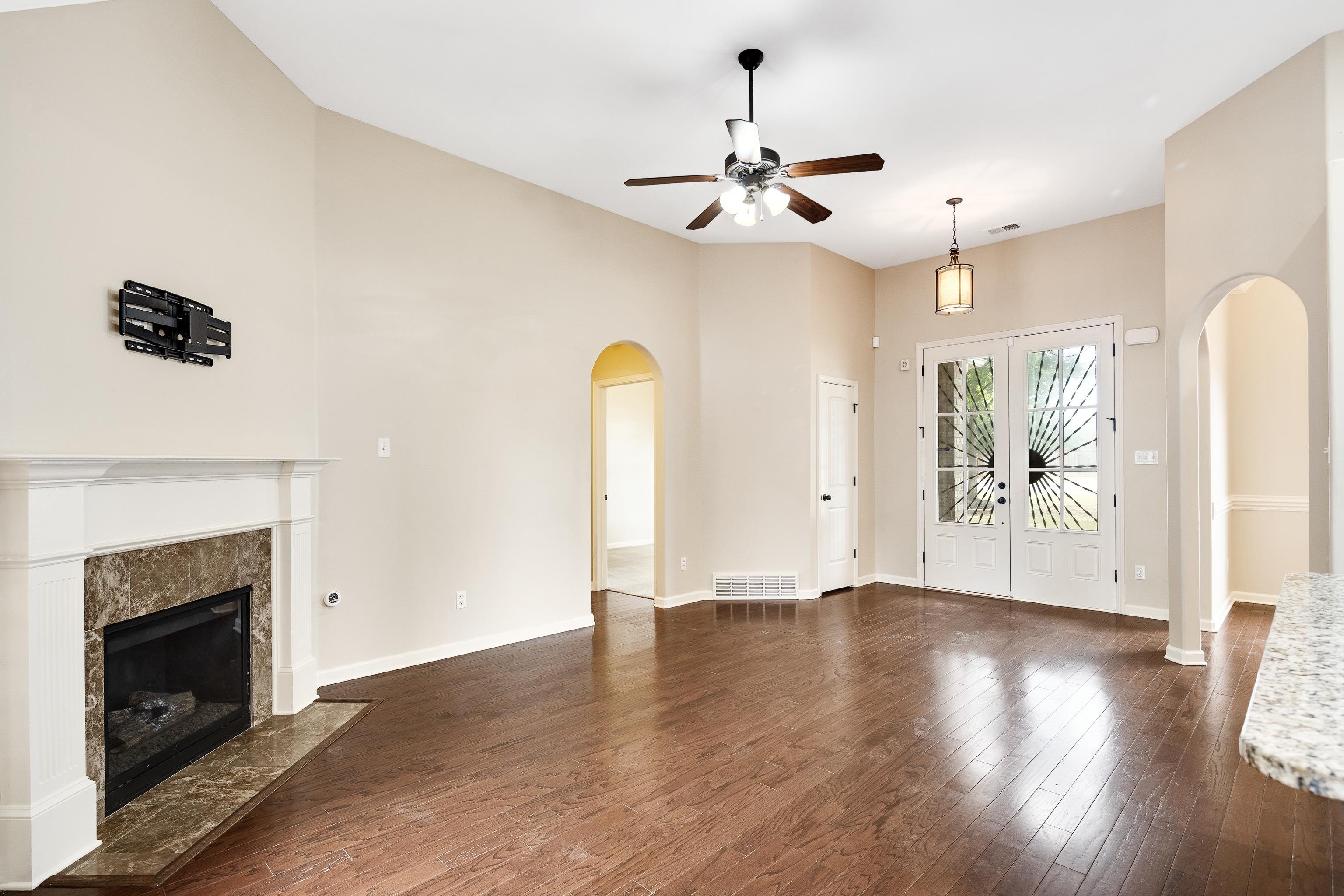 379 Shelton Road Collierville, TN 38017 - Photo 8 of 32 a view of an empty room with wooden floor and a fireplace