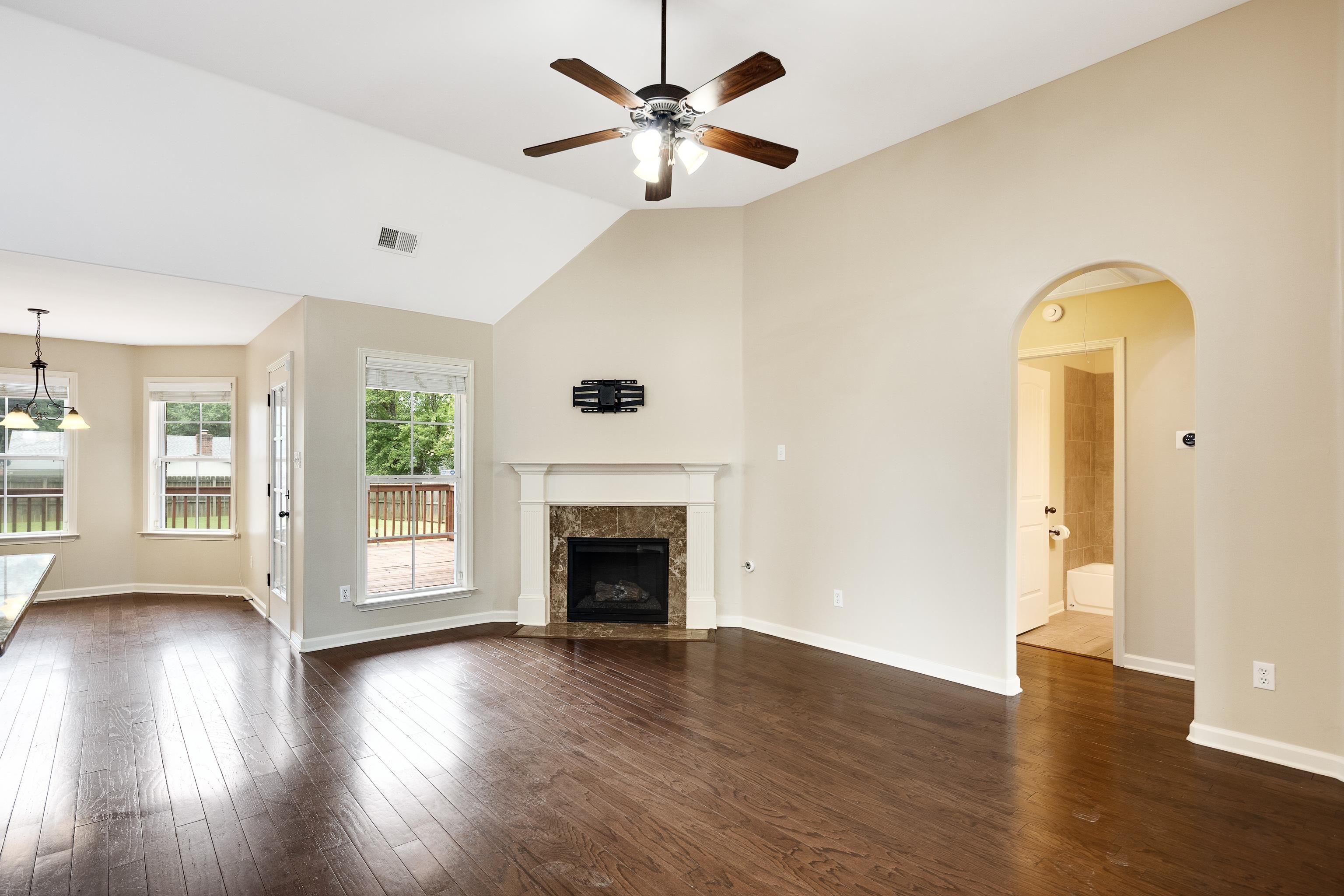 379 Shelton Road Collierville, TN 38017 - Photo 9 of 32 an empty room with wooden floor a fireplace and a window