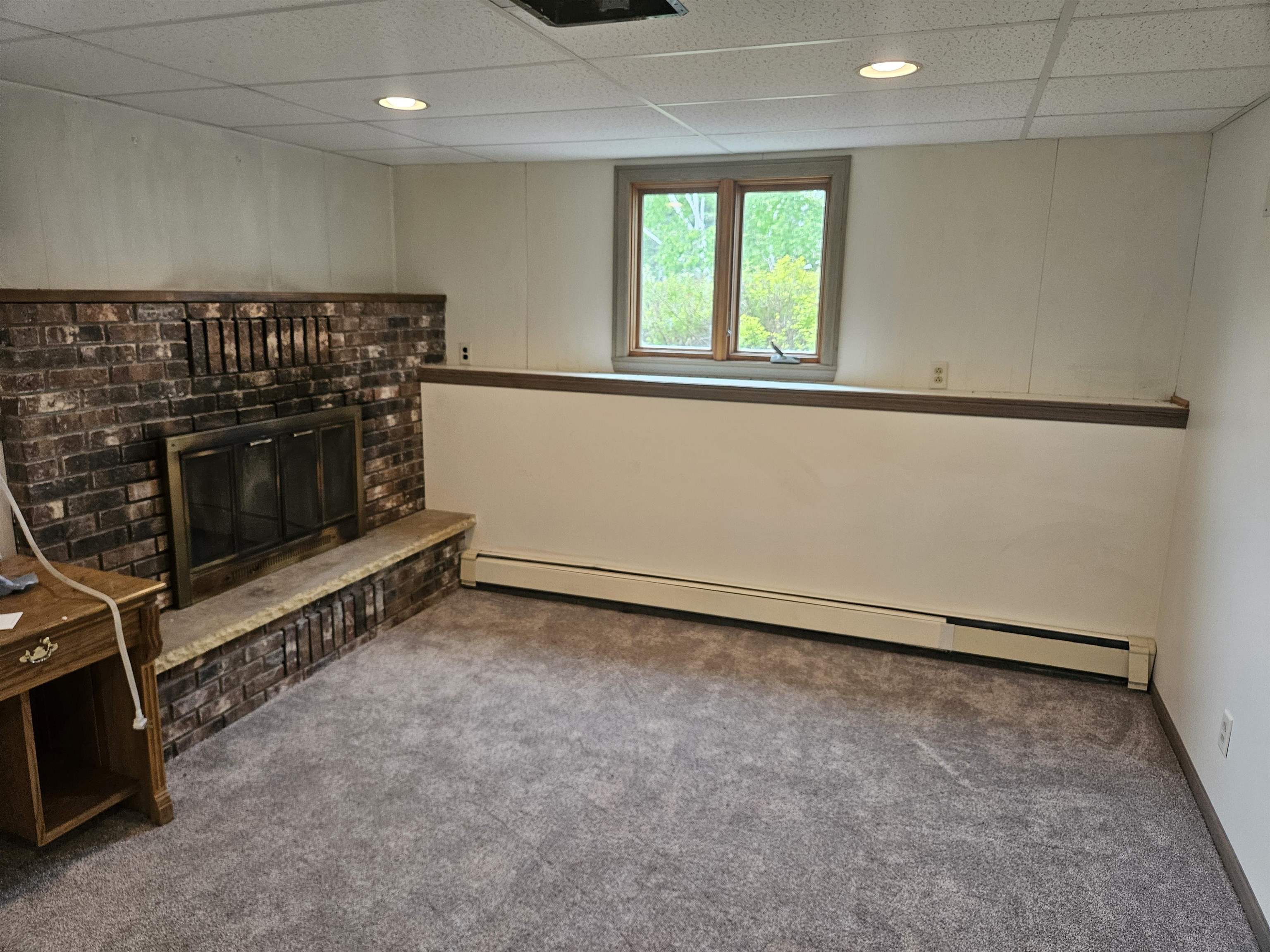 84 Erickson Road Esko, MN 55733 - Photo 11 of 16 Basement with carpet flooring, baseboard heating, a fireplace, and a paneled ceiling