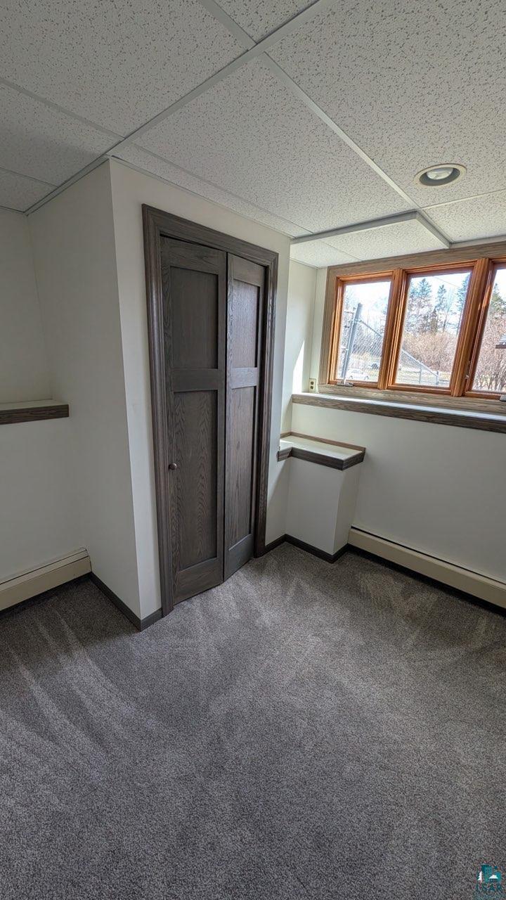 84 Erickson Road Esko, MN 55733 - Photo 15 of 16 Wall-to-wall gray carpet flooring, dark wood-finish bi-fold closet doors, and a wood-finish bay window frame