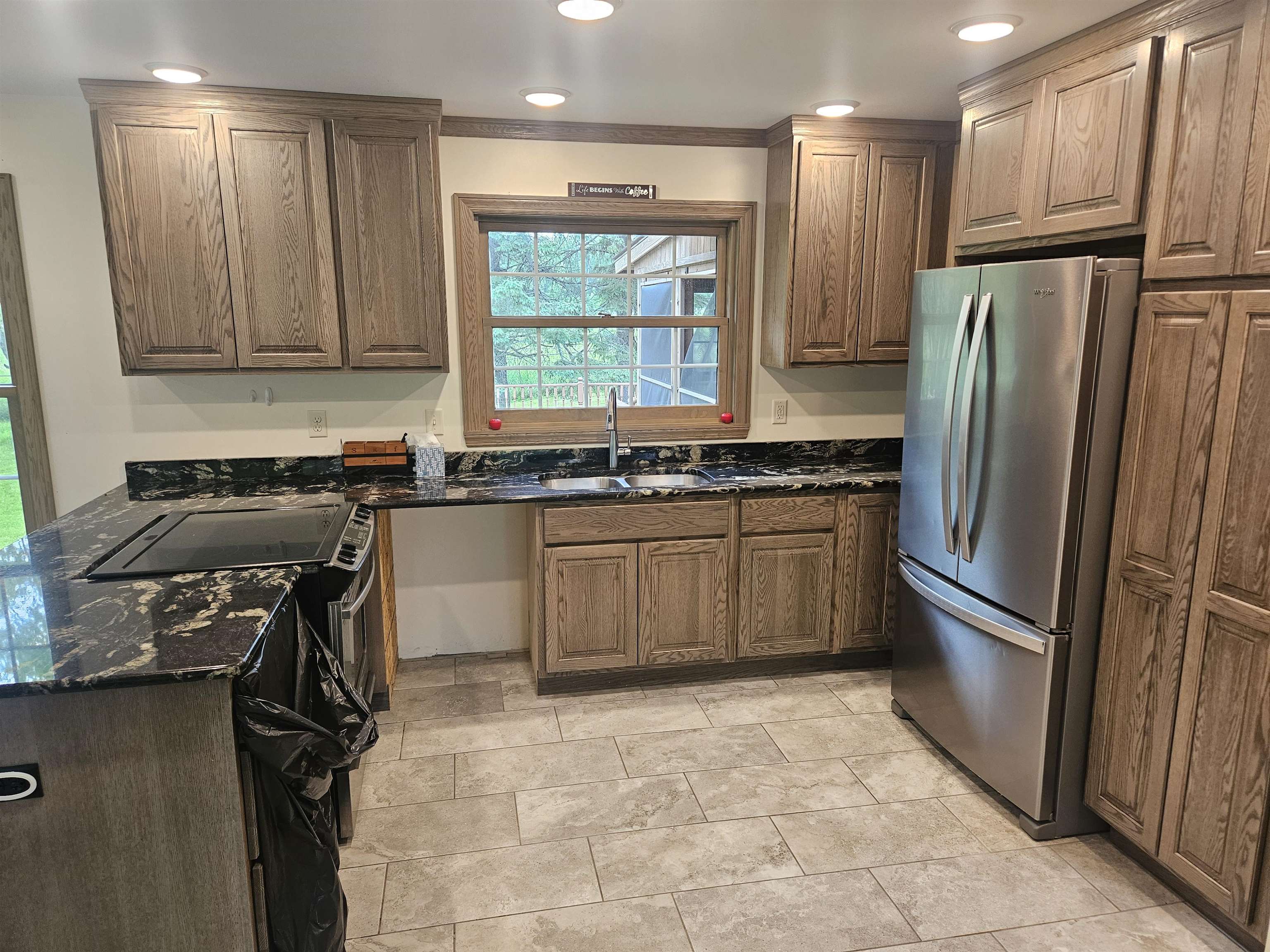 84 Erickson Road Esko, MN 55733 - Photo 7 of 16 Kitchen featuring freestanding refrigerator, dark stone countertops, a peninsula, brown cabinets, and recessed lighting