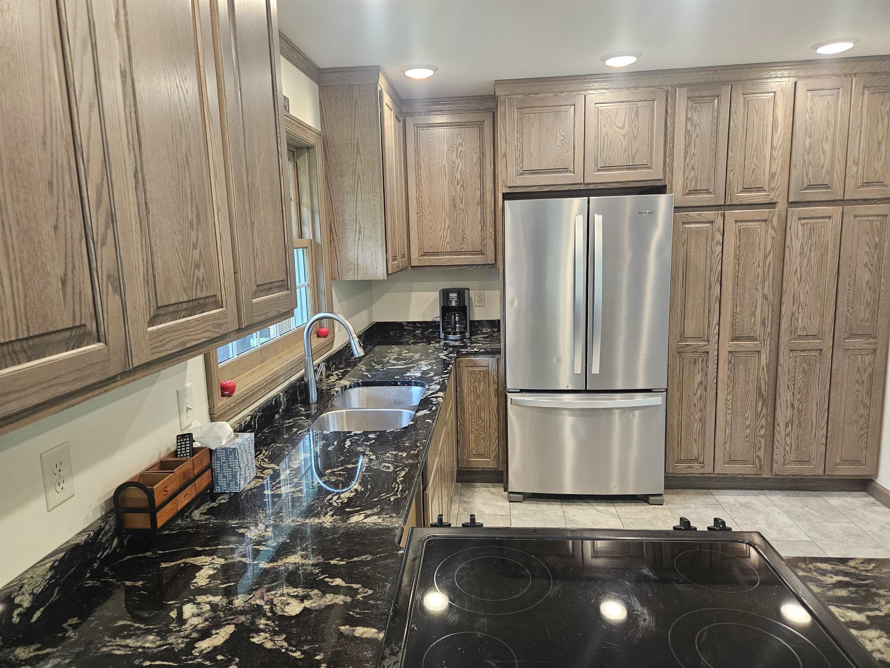 84 Erickson Road Esko, MN 55733 - Photo 10 of 16 Kitchen with freestanding refrigerator, dark stone counters, black electric stovetop, and brown cabinets