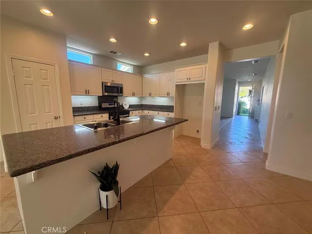 a kitchen with stainless steel appliances granite countertop a refrigerator and a stove top oven