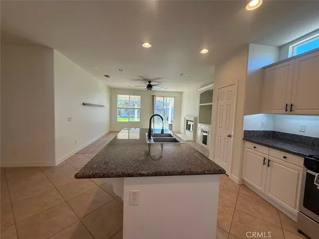 a kitchen with granite countertop a sink a stove and a refrigerator