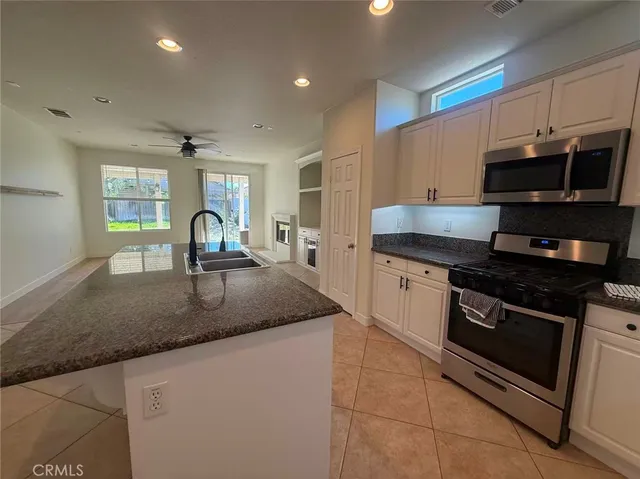 a kitchen with granite countertop a sink and a stove top oven with wooden floor