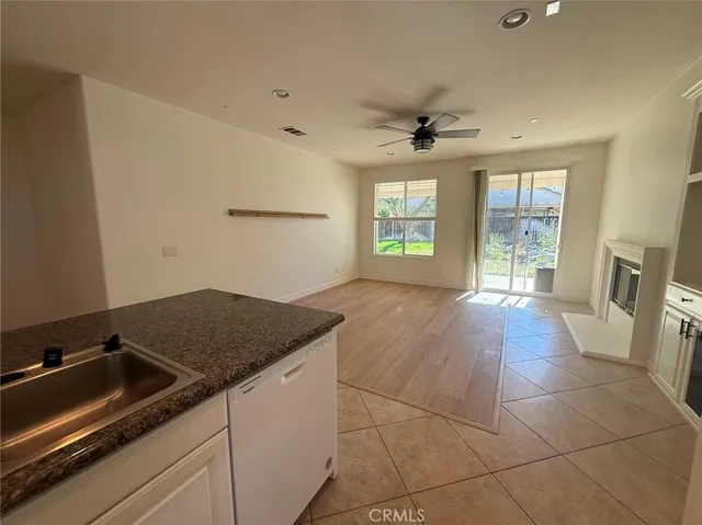 a kitchen with a sink a stove cabinets and a glass door