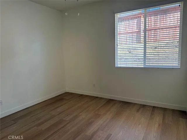 a view of a small space with wooden floor and a window