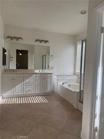 a bathroom with a tub a sink and mirrors