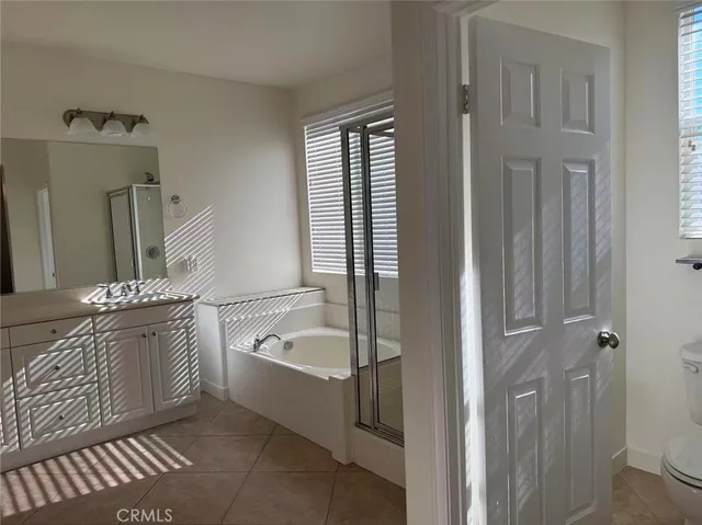 a en suite bathroom with a tub sink and mirror